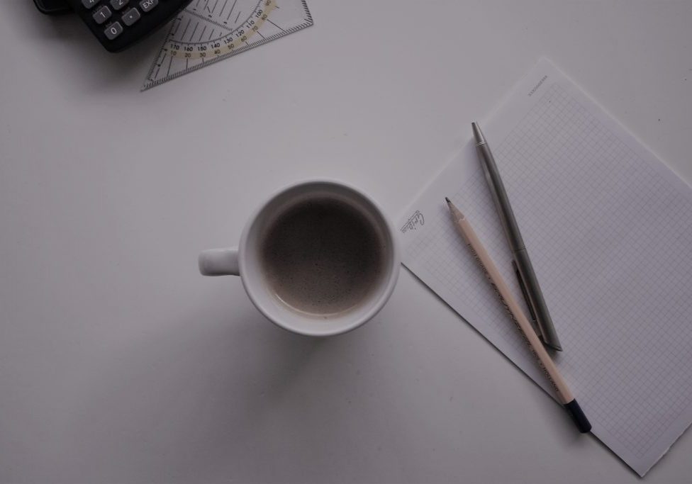 potloden op notitieblok met mok koffie tijdens grip op leren bijles